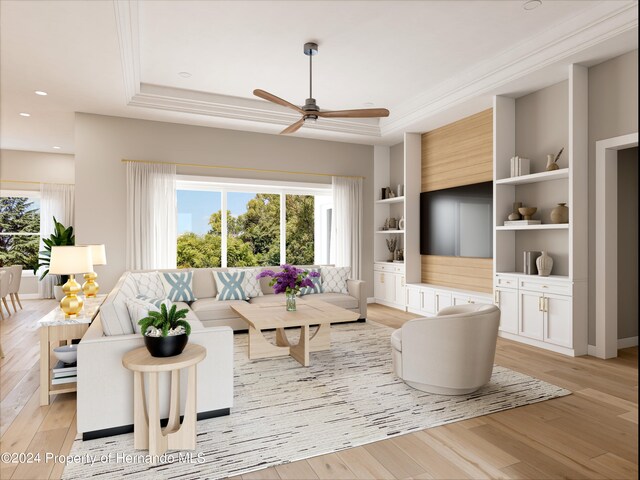 living room with light hardwood / wood-style floors, built in shelves, and a tray ceiling