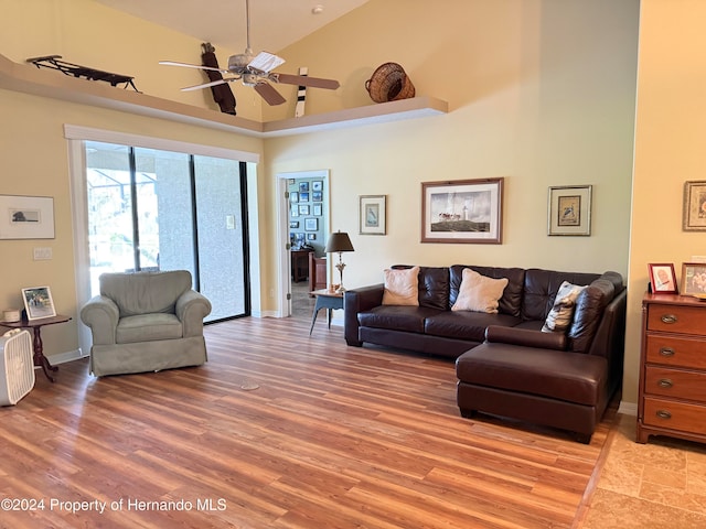 living room with ceiling fan, light hardwood / wood-style flooring, and high vaulted ceiling