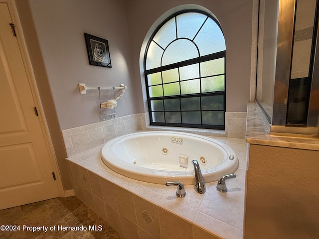 bathroom featuring tiled bath and tile patterned flooring