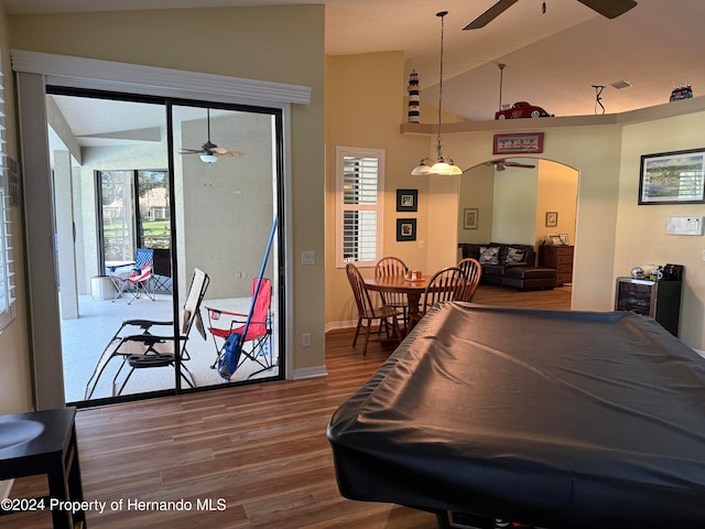 rec room with pool table, a wealth of natural light, vaulted ceiling, and hardwood / wood-style flooring