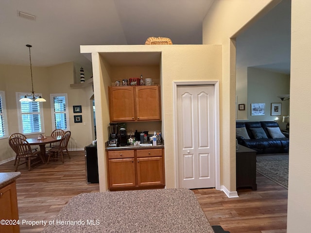 kitchen featuring high vaulted ceiling, dark wood-type flooring, and decorative light fixtures