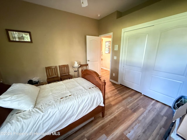 bedroom featuring hardwood / wood-style floors, ceiling fan, and a closet