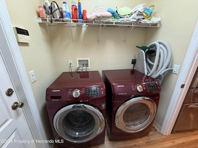 washroom featuring washing machine and clothes dryer and light wood-type flooring