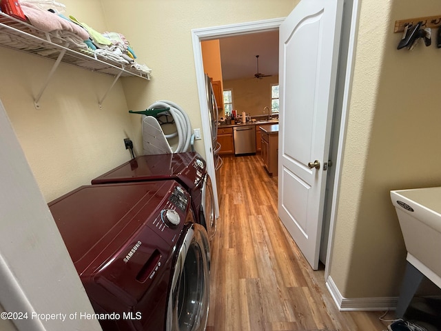 laundry room with light hardwood / wood-style floors, ceiling fan, and washing machine and clothes dryer