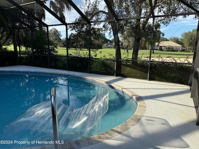 view of swimming pool featuring glass enclosure