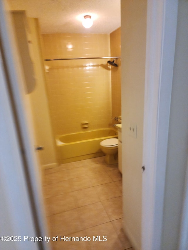 bathroom featuring tub / shower combination, toilet, and tile patterned floors