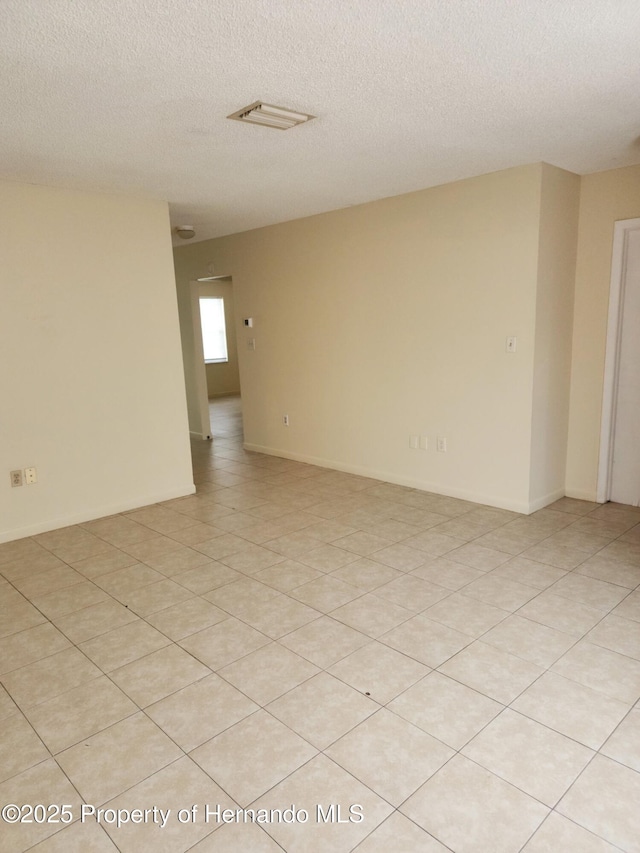 empty room with baseboards and a textured ceiling