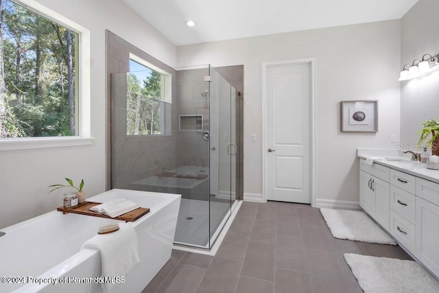 bathroom featuring tile patterned flooring, vanity, and plus walk in shower