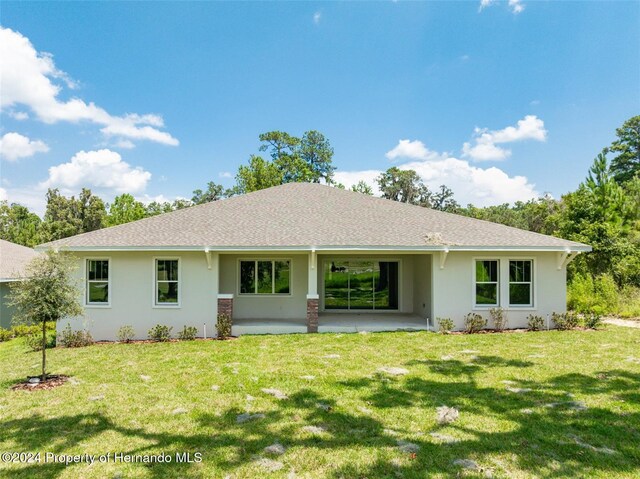 6436 Summit View Dr, Brooksville, FL 34601 - rear view of house with stucco siding, roof with shingles, and a lawn