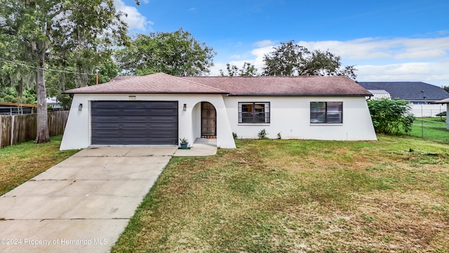 ranch-style home featuring a garage and a front lawn