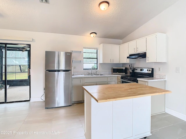 kitchen featuring white cabinets, sink, vaulted ceiling, a textured ceiling, and stainless steel appliances