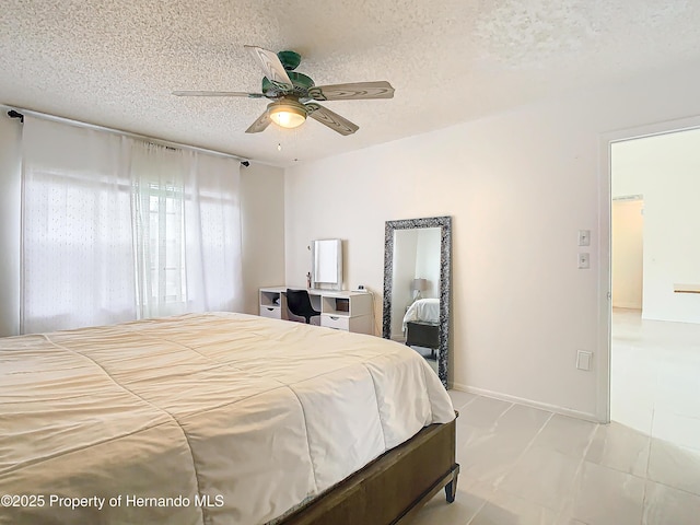 bedroom with ceiling fan and a textured ceiling