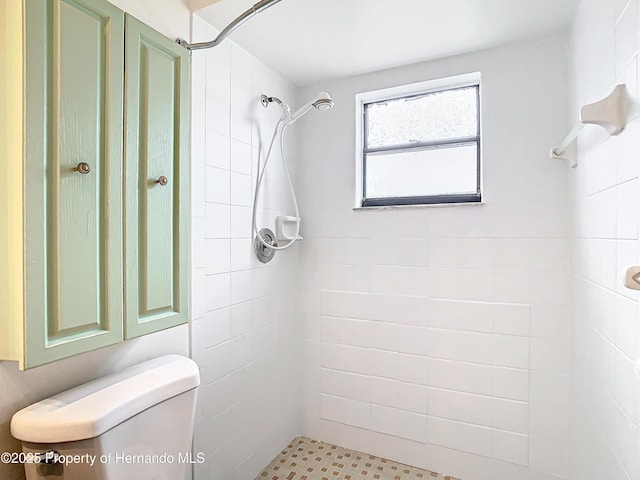 bathroom featuring toilet and tiled shower