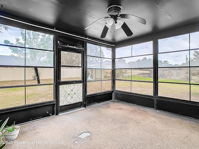 unfurnished sunroom featuring ceiling fan