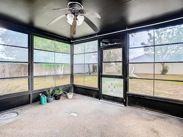 unfurnished sunroom featuring ceiling fan