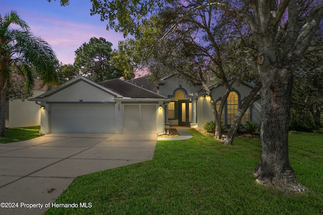 view of front of property featuring a garage and a lawn