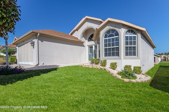 back of house featuring a garage and a lawn