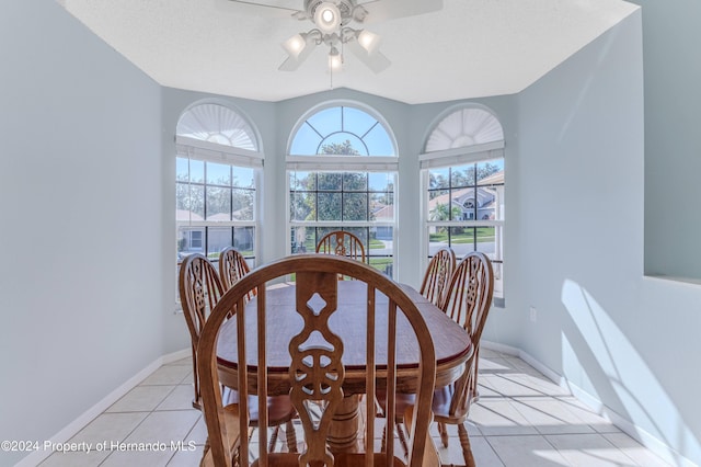 tiled dining room with ceiling fan and vaulted ceiling