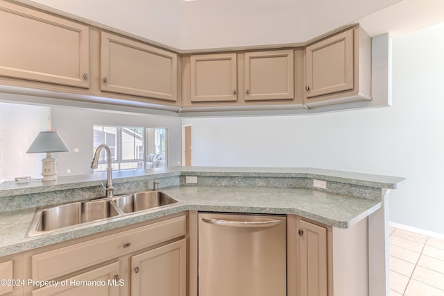 kitchen featuring light brown cabinetry, stainless steel dishwasher, sink, and light tile patterned floors