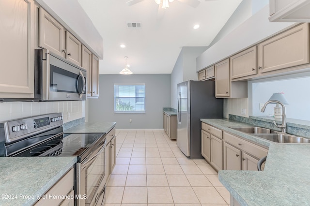 kitchen with stainless steel appliances, lofted ceiling, sink, light tile patterned floors, and backsplash