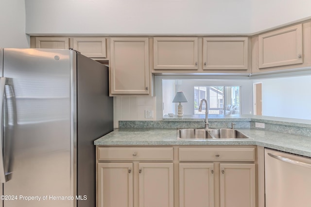 kitchen featuring backsplash, appliances with stainless steel finishes, sink, and cream cabinets