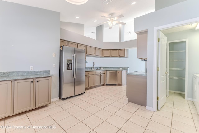 kitchen with light brown cabinetry, sink, light tile patterned floors, and stainless steel appliances