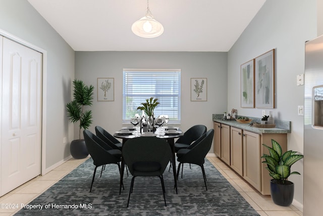 dining space with light tile patterned flooring and vaulted ceiling