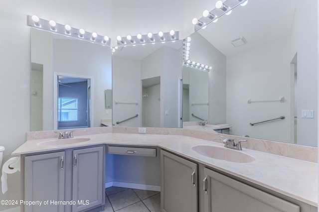 bathroom with vanity, tile patterned floors, and vaulted ceiling