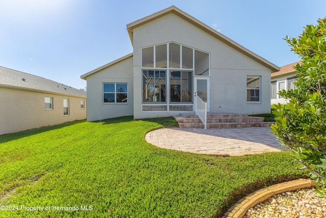 rear view of house featuring a patio, a sunroom, and a yard