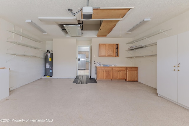 garage featuring water heater, a garage door opener, and stainless steel refrigerator with ice dispenser