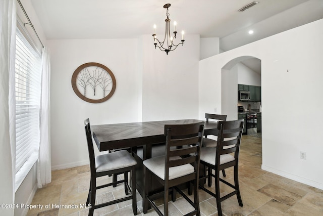 dining space with an inviting chandelier and lofted ceiling