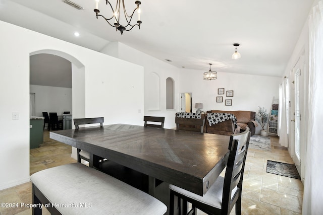 dining area featuring an inviting chandelier and lofted ceiling