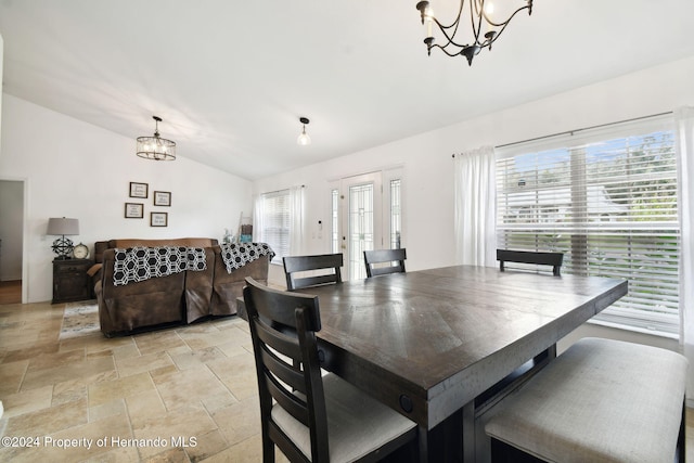 dining room with vaulted ceiling and a notable chandelier