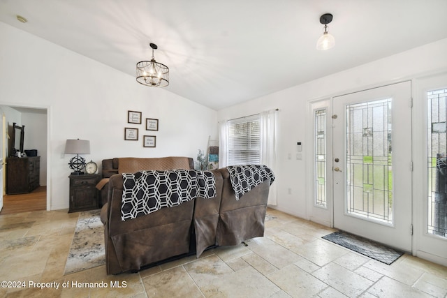 living room with a chandelier, vaulted ceiling, and a healthy amount of sunlight