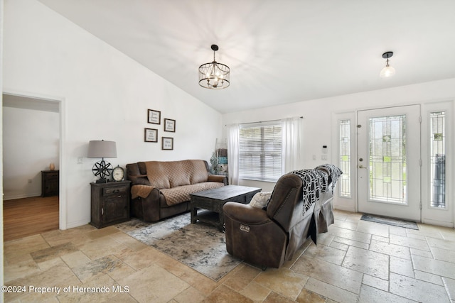 living room featuring lofted ceiling and a chandelier