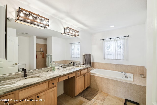 bathroom featuring vanity and independent shower and bath