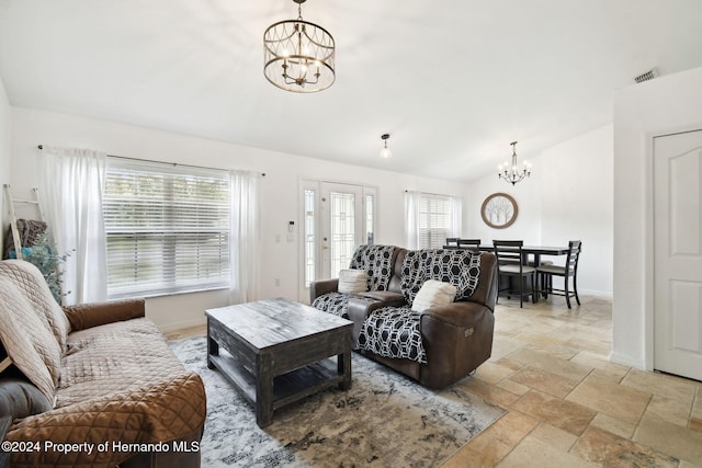 living room with plenty of natural light, vaulted ceiling, and a chandelier