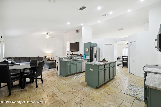 kitchen featuring lofted ceiling, green cabinetry, ceiling fan, appliances with stainless steel finishes, and a kitchen island