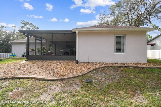 back of property with a sunroom