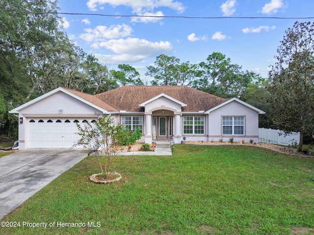 ranch-style home featuring a front lawn and a garage