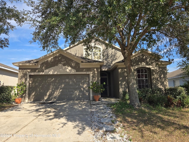 view of front of property with driveway, an attached garage, and stucco siding