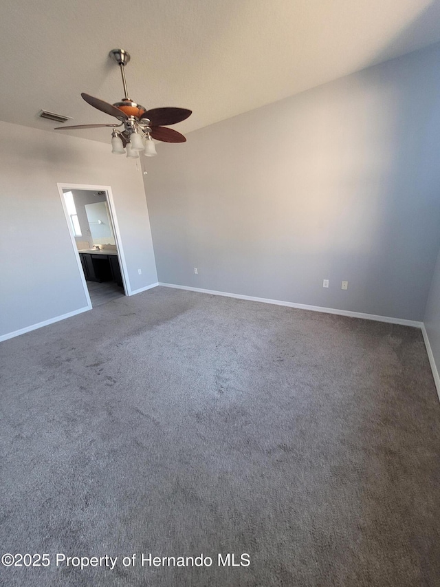 unfurnished bedroom featuring carpet, visible vents, a ceiling fan, ensuite bath, and baseboards