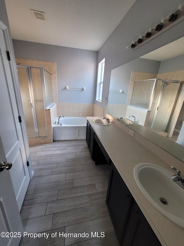 full bath featuring a bath, a stall shower, visible vents, and a sink