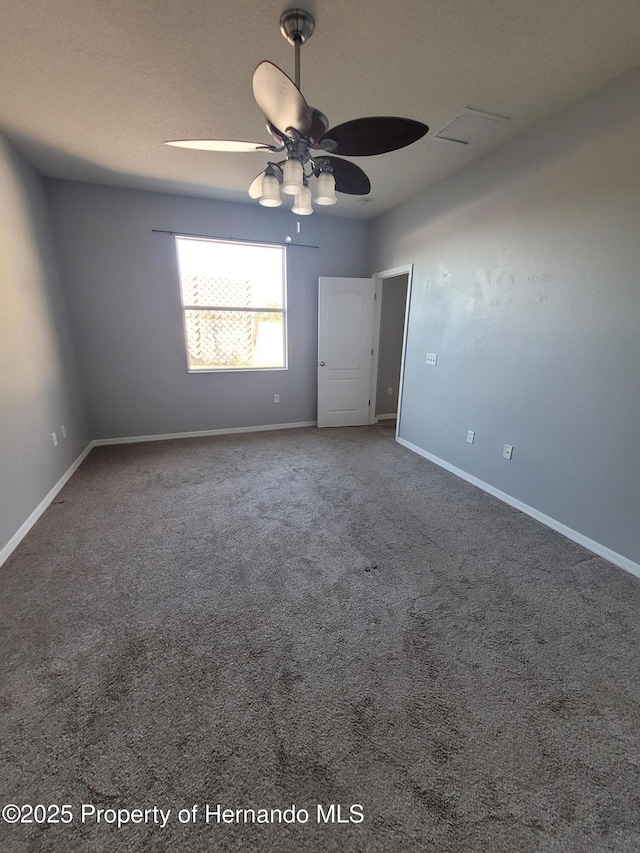 carpeted spare room with ceiling fan and baseboards