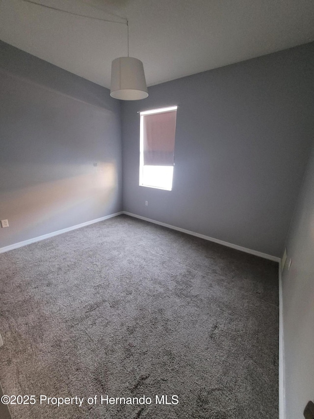 empty room featuring carpet flooring and baseboards