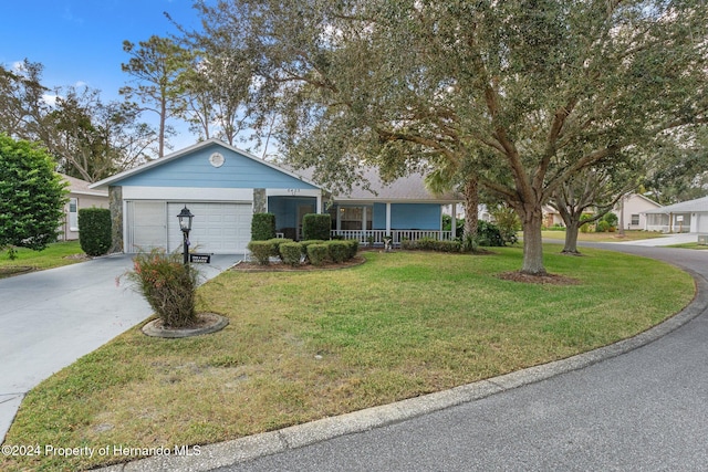 ranch-style house with covered porch, a garage, and a front yard