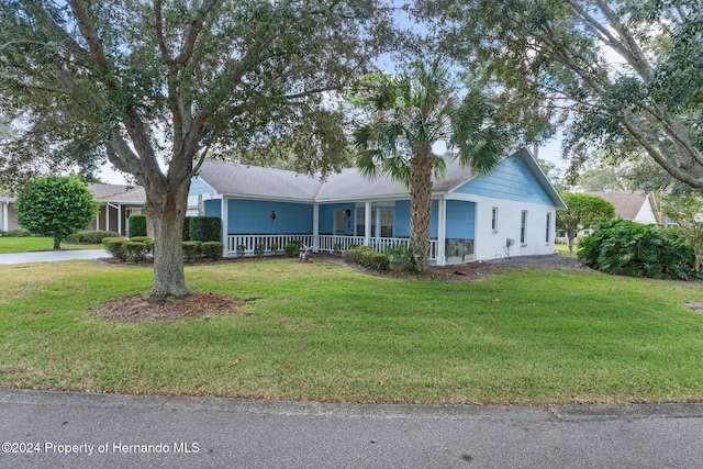 ranch-style house with a front yard and covered porch