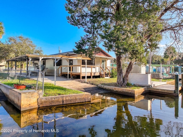 back of property featuring a deck with water view