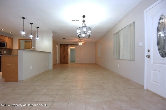 unfurnished living room with light tile patterned floors and ceiling fan with notable chandelier