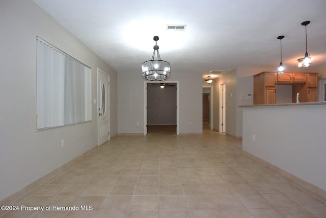 unfurnished room featuring light tile patterned floors and a notable chandelier